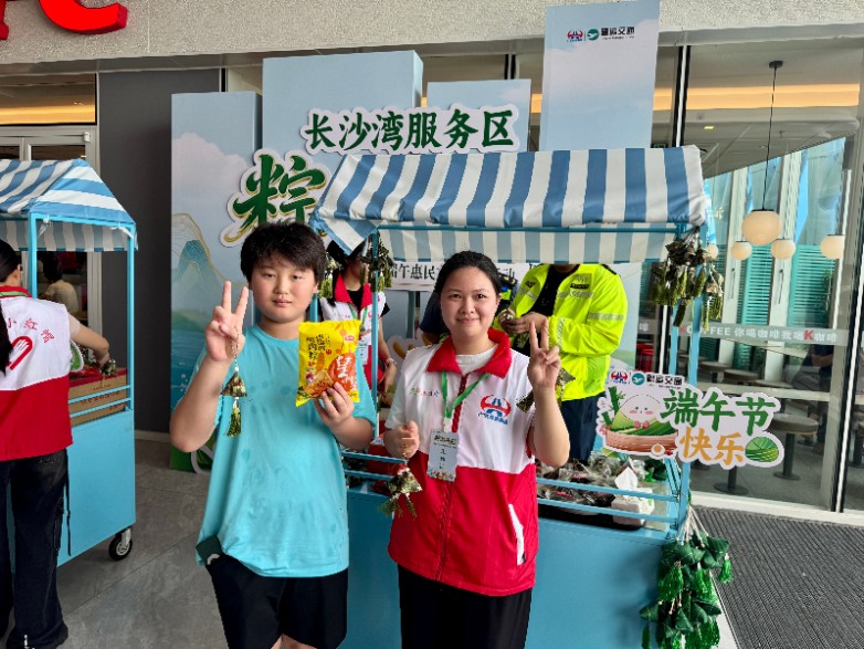 小朋友在长沙湾服务区领取免费粽子后开心与志愿者合影（摄影：张婵英）.jpg